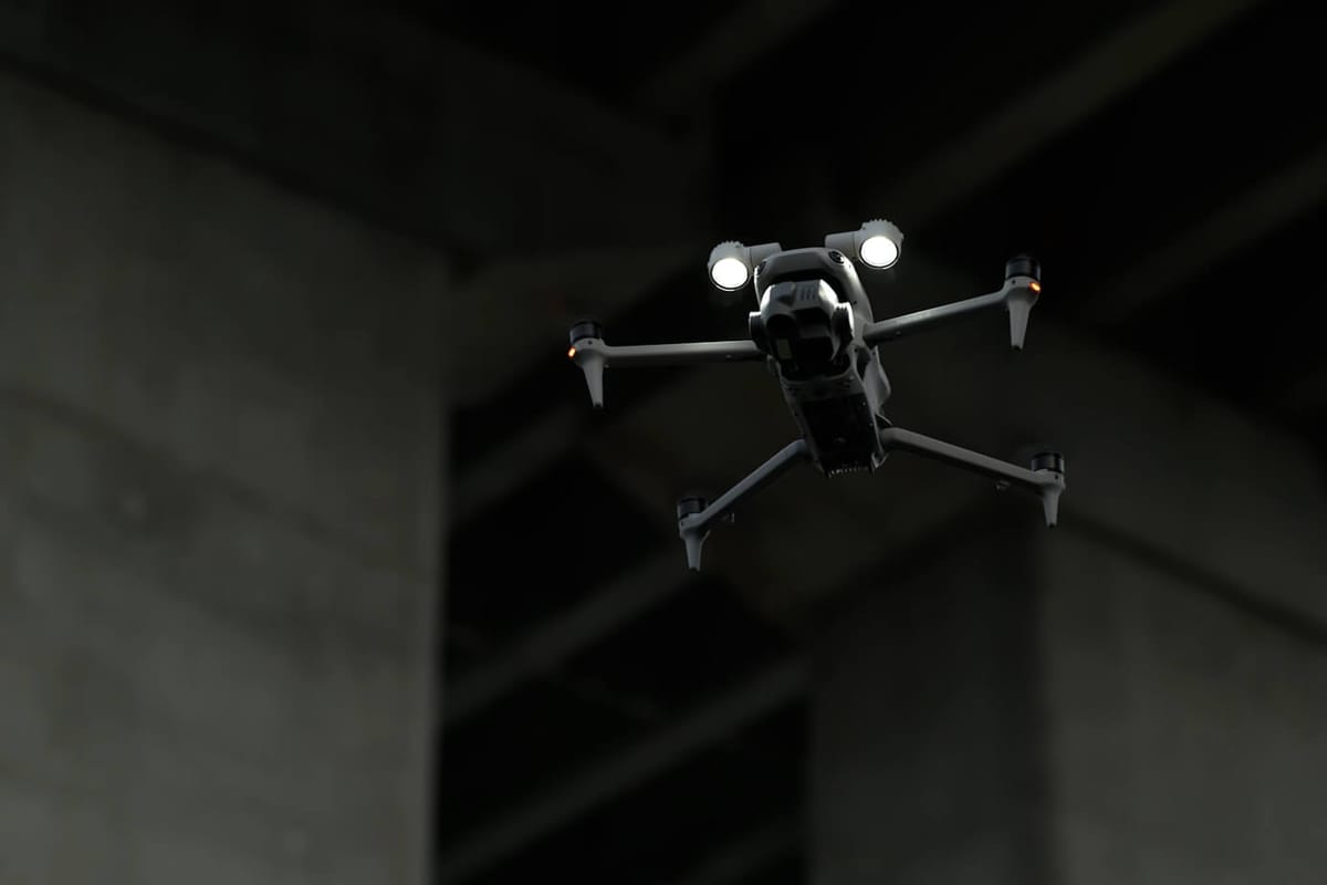 DJI Matrice-series drone with onboard lights flying beneath a concrete structure