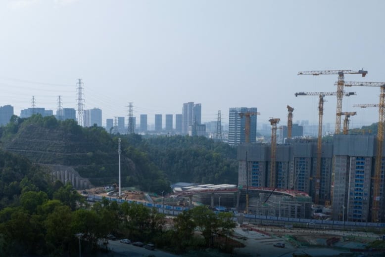 Construction site with tower cranes and a high-rise building under construction