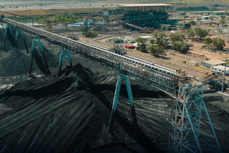 Aerial view of an industrial plant with a conveyor and material stockpile