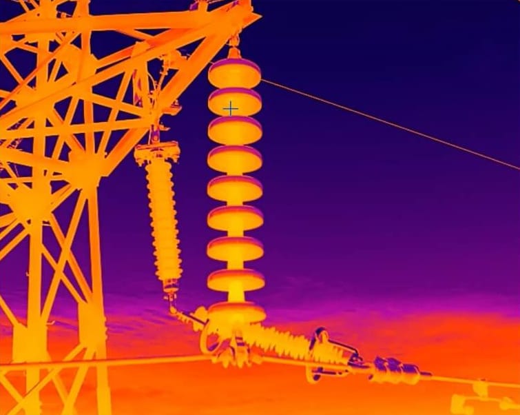 Thermal image of insulators on a power transmission tower, shown with a temperature scale